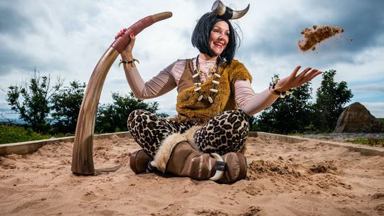 Cavewoman in sand pit