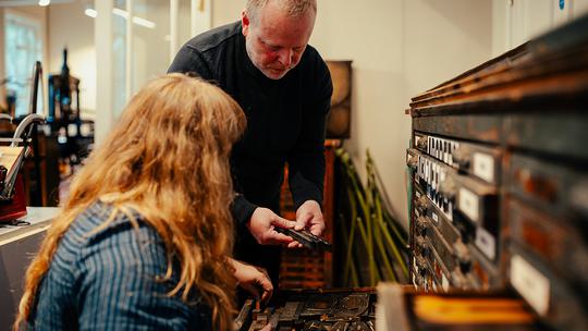 Izzy and Phil opening a case of wood type and ornaments