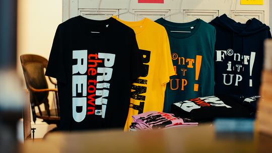 T-shirts and hoodies on display in the shop at Thin Ice Press